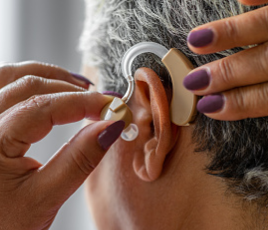 Women putting on hearing aid